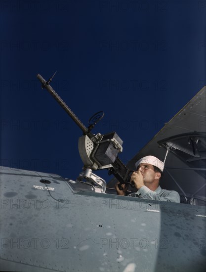 He's like to use that gun on the Axis, Naval Air Base, Corpus Christi, Texas, 1942. Creator: Howard Hollem.