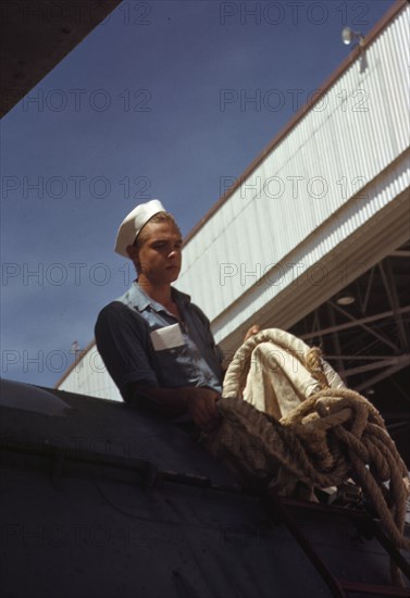 Sailor mechanic inspecting a PBY plane at the Naval Air Base, Corpus Christi, Texas, 1942. Creator: Howard Hollem.