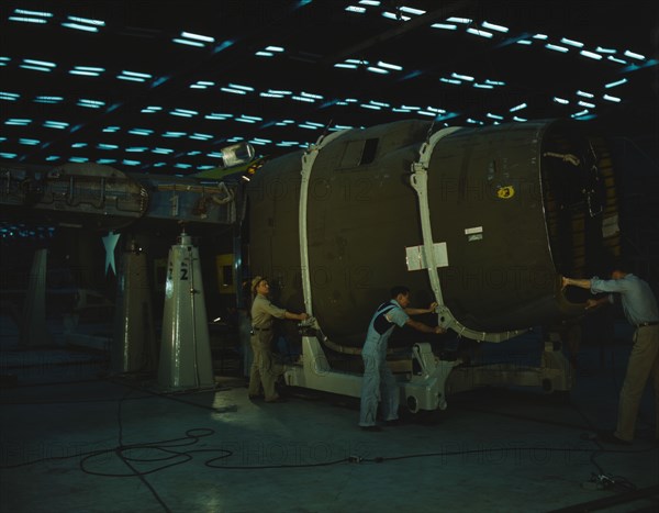 Putting the nose section of a mighty transport...Consolidated Aircraft..., Fort Worth, Texas, 1942. Creator: Howard Hollem.