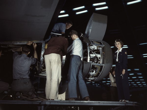 Installing an engine at the Consolidated Aircraft Corporation plant, Fort Worth, Texas, 1942. Creator: Howard Hollem.