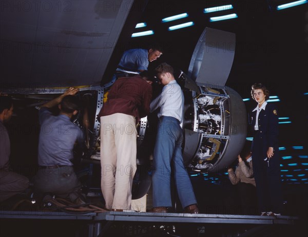 Installing an engine at the Consolidated Aircraft Corporation plant, Fort Worth, Texas, 1942. Creator: Howard Hollem.