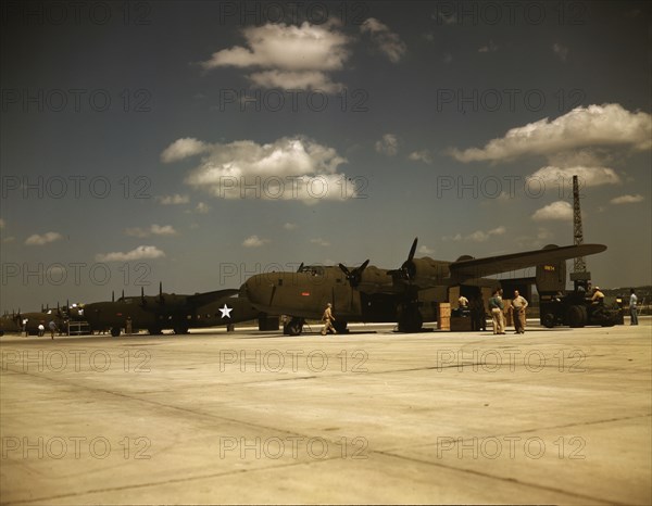 Consolidated transport planes being loaded, Consolidated Aircraft Corp., Fort Worth, Texas, 1942. Creator: Howard Hollem.