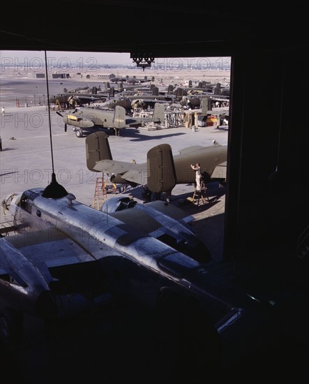 Another North American B-25 bomber rolls off the final assembly line to join other ships..., 1942. Creator: Alfred T Palmer.