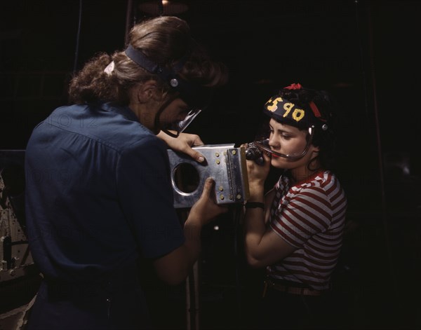 Two women employees of North American Aviation, Incorporated, assembling a section of a..., 1942. Creator: Alfred T Palmer.