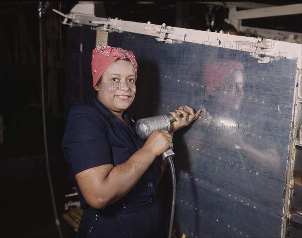 Operating a hand drill at Vultee-Nashville, woman is working on a "Vengeance" dive..., Tenn., 1943. Creator: Alfred T Palmer.