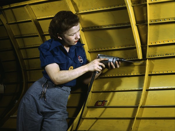 Operating a hand drill at Vultee-Nashville, woman is working on a "Vengeance" dive..., Tenn., 1943. Creator: Alfred T Palmer.