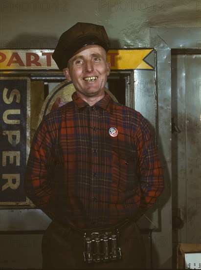 Garage mechanic near Newark, N.J. Badge denotes member of Office of Defense Transportation, 1943. Creator: Marjory Collins.