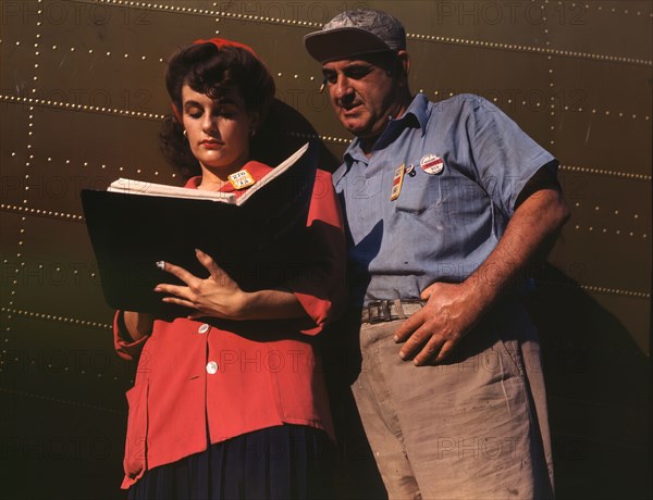 Girl inspector confers with a worker as she..., Douglas Aircraft Company, Long Beach, Calif., 1942. Creator: Alfred T Palmer.