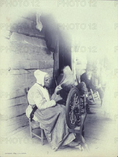 Elderly woman sitting on porch spinning, c1894.