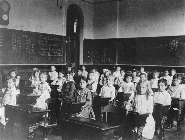 Girls and boys seated at desks in classroom, Washington, D.C., (1899?).