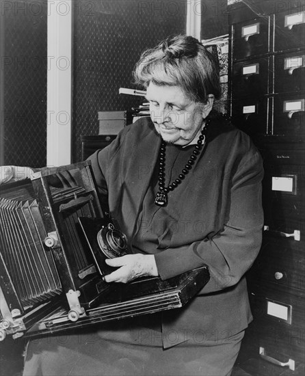 Frances Benjamin Johnston, three-quarter length portrait, holding and looking down..., c1950. Creator: Unknown.