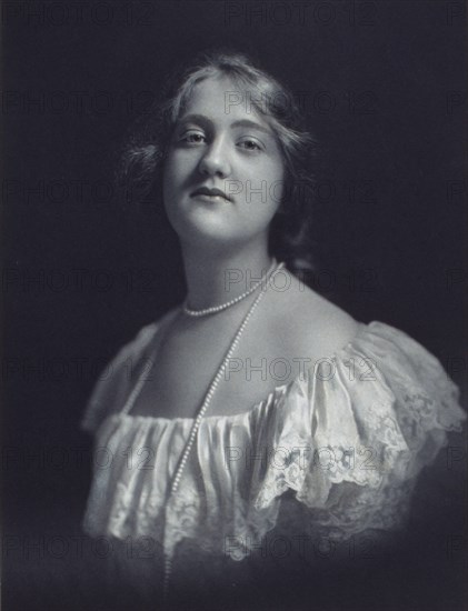 Young woman wearing an off-the-shoulder dress and long pearl necklace, looking front..., c1900. Creator: F. Gercher.