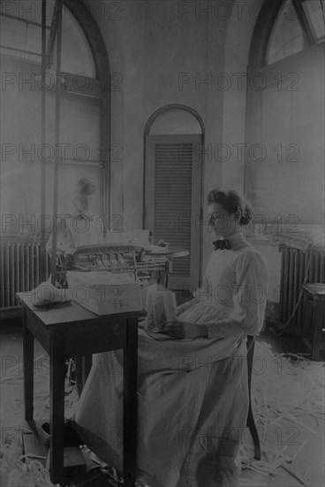 Women trimming and stacking currency sheets at the Bureau of Engraving & Printing, c1890.