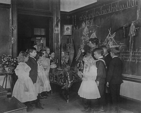 Teacher showing students Native American handicrafts at a school in Washington, D.C., (1899?).