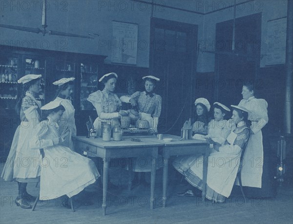 Eight teenage girls wearing aprons and chef caps learning to cook...Washington DC high school, 1899? Creator: Frances Benjamin Johnston.