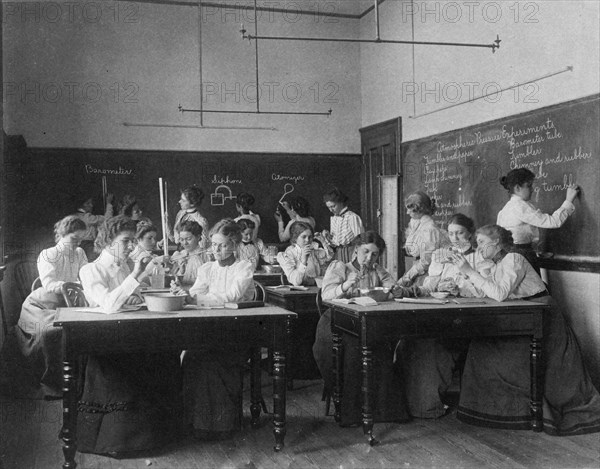 Group of young women performing atmospheric pressure experiments while studying..., (1899?). Creator: Frances Benjamin Johnston.