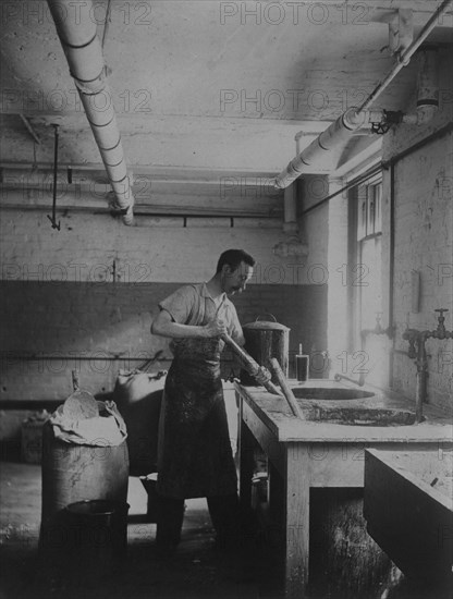 Worker prepares gum for postage stamps in the Stamp Division at the Bureau of Engraving & Printing, c1895.