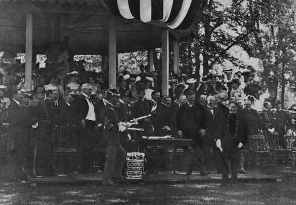 Graduation Day at Annapolis - cadet receiving his diploma from President Theodore Roosevelt, 1902. Creator: Frances Benjamin Johnston.