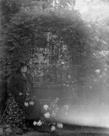 Frances Benjamin Johnston, photographer, posed sitting with peonies..., Takoma Park, Maryland, 1938. Creator: Unknown.