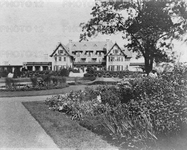 Facade of home of Edmund Cogswell Converse, with flowers in foreground, Greenwich, Connecticut, 1908 Creator: Frances Benjamin Johnston.