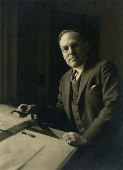 Leicester B. Holland, Chief of Fine Arts Division, Library of Congress posed...table, (1930?). Creator: Frances Benjamin Johnston.