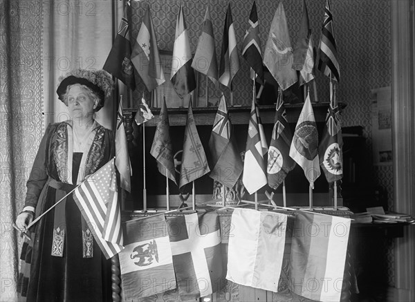 Mrs. Carrie Chapman Catt with Flags of 22 Nations, 1917. Creator: Harris & Ewing.