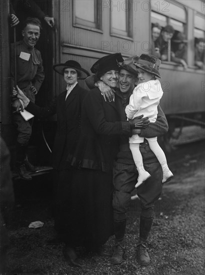 Army, U.S. Troops In Training, 1917. Soldier hugs his family before leaving on a packed train.