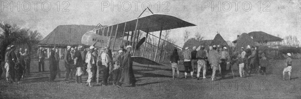 'La retraite de nos aviateurs par l'Albanie; Biplan entoure par la population masculine..., 1916. Creator: Unknown.