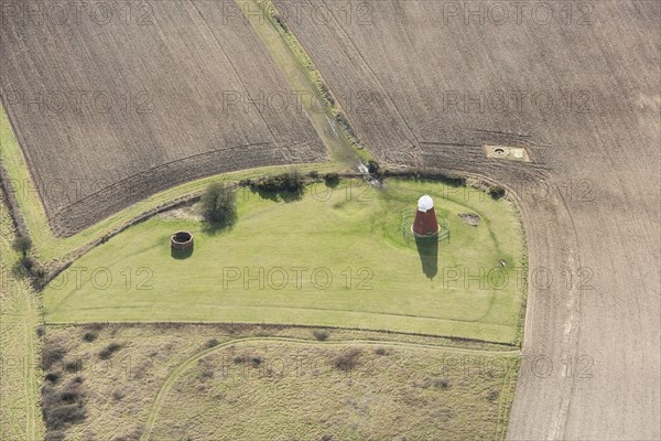 A tower windmill and World War II searchlight emplacements on Halnaker Hill causewayed enclosure, West Sussex, 2018.