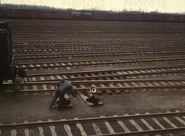 Switchman throwing a switch at C & NW RR's [i.e. Chicago and North Western railroad's] Proviso yard, Chicago, Ill.