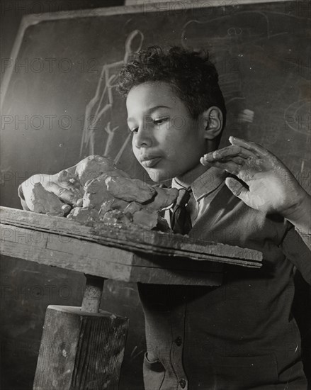 Boy sculpting, Harlem Art Center, 1939.