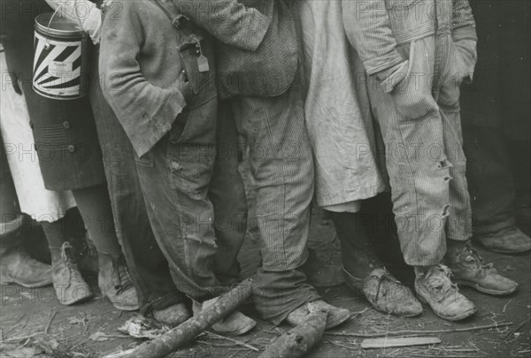 A detailed shot of flood refugees' feet showing their shoes; Forrest City, Arkansas, 1930s. Creators: Farm Security Administration, Walker Evans.