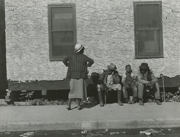 Two African American men and one African American boy sitting and one African..., Jan 1939. Creators: Farm Security Administration, Marion Post Wolcott.