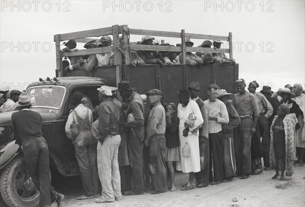 Vegetable pickers, migrants, waiting after work to be paid, near Homestead, Florida, February 1939.
