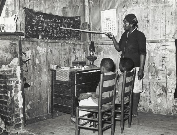 Negro mother teaching children numbers and alphabet in home of sharecropper, Transylvania, Louisiana, January 1939.