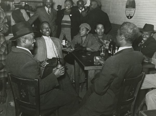 African Americans conversing and drinking beers in a bar, Clarksdale, Mississippi Delta, November 1939.