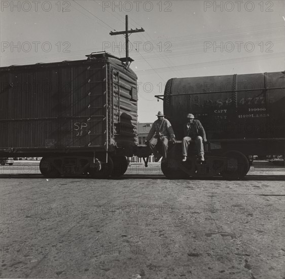 Colored itinerants on oil tank cars passing through Kingsbury, California, 1938.