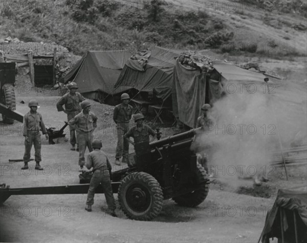 Vietnamese artillerymen fire from a mountain position during field training, 1962.