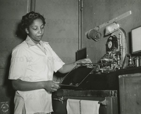 African American Private Hannah Wills developing an x-ray film in the x-ray laboratory..., 1943. Creator: Unknown.