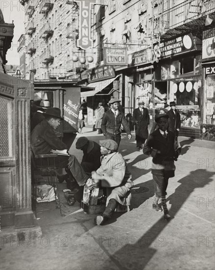 View of Lenox Avenue, Harlem, at 135th Street, showing businesses, pedestrians and shoe-shine stand, March 23, 1939.