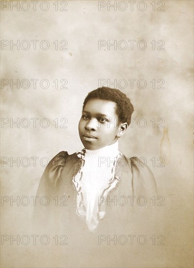 Studio portrait of young woman, c1890-c1899. Creators: M Yogg, Unknown.