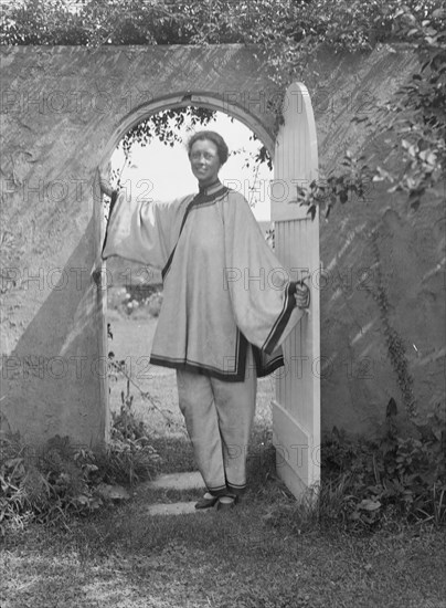 King, Hamilton, Mrs., standing in a garden door, 1932 Creator: Arnold Genthe.