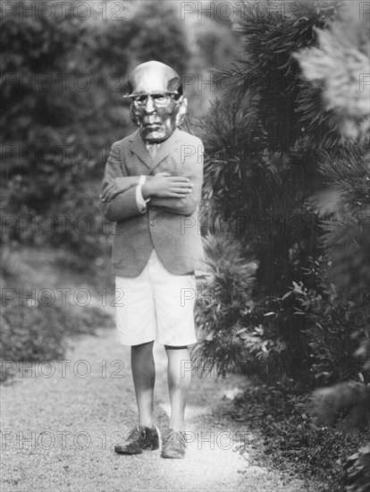 Person wearing a mask made by W.T. Benda, 1925 Sept. 20. Creator: Arnold Genthe.