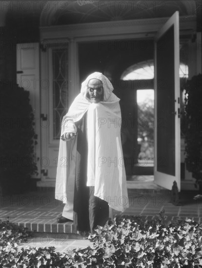 Person wearing a mask made by W.T. Benda, 1925 Sept. 20. Creator: Arnold Genthe.