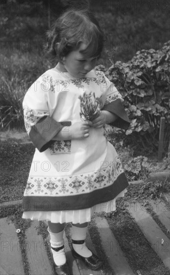 Unidentified child, standing outdoors, between 1911 and 1942. Creator: Arnold Genthe.