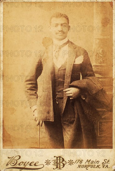 Dapper man, coat draped over his arm, and cane in hand, c1880-c1889. Creator: Unknown.