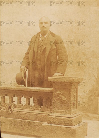 Studio portrait of man dressed in suit and coat, holding bowler hat, c1890. Creator: Steinhardt.