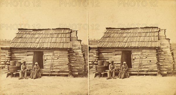 Uncle Ben's cabin, [Elderly couple sitting in front of a cabin], (1868-1900?). Creator: Unknown.