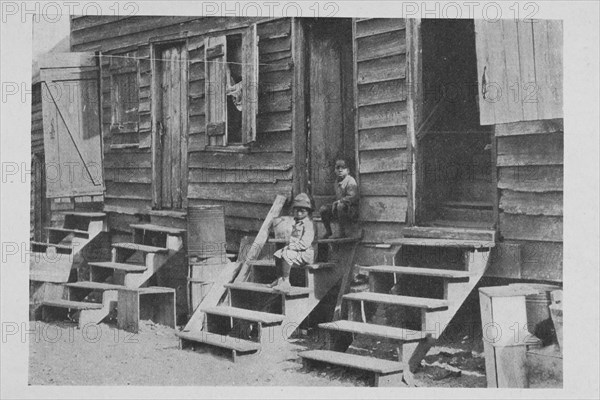 African American children sitting on the stairs in front of their house, 1922. Creator: Unknown.