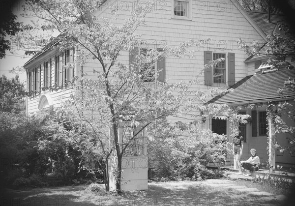 DeLamar, Alice, Miss, and unidentified woman by house, between 1927 and 1942. Creator: Arnold Genthe.